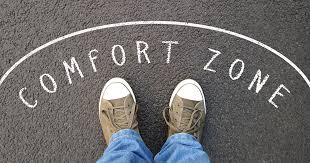 A pair of shoes standing on a pavement marking that reads 'COMFORT ZONE'.